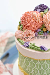 精致裱花蛋糕特写：粉色褶皱奶油花与绿叶装饰