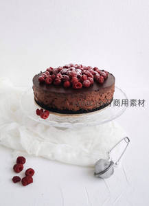 浓郁巧克力慕斯蛋糕顶铺鲜红覆盆子，撒糖粉点缀，晶莹玻璃架衬纯白背景