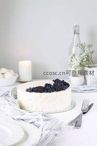 白霜浆果蛋糕餐桌布置，黑莓蓝莓点缀纯白奶油，烛光与小花瓶营造温馨仪式感