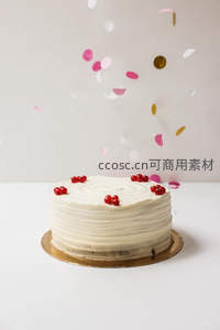 白色奶油蛋糕撒红浆果与彩纸屑，简约庆祝风