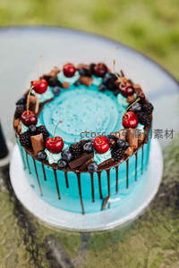 蓝莓樱桃巧克力 drip cake，青蓝奶油配鲜果与巧克力碎，户外玻璃桌拍摄