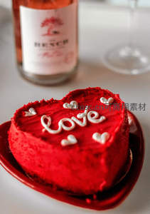 心形红丝绒蛋糕写‘love’字样，配玫瑰酒瓶与高脚杯，情人节浪漫摆拍
