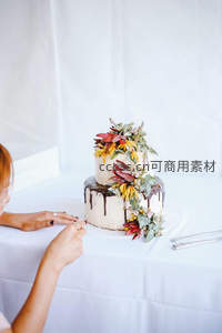 双层鲜花装饰婚礼蛋糕，新人手执刀具切开浪漫瞬间