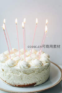 点燃蜡烛的奶油芝士蛋糕，简约生日氛围