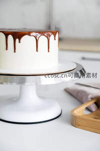 白色奶油蛋糕淋上浓郁巧克力酱，滴落效果诱人，置于旋转蛋糕台