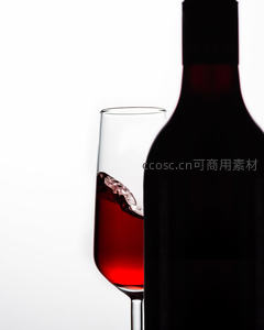 白底剪影红酒瓶与动态溅起酒液的高脚杯特写