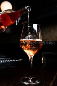 暗调光影下玫瑰酒倾入高脚杯，气泡升腾，质感高级