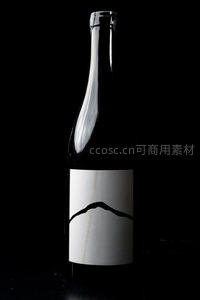 简约山形标签黑瓶酒瓶特写，高对比暗调静物摄影