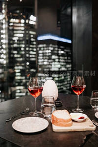 都市夜景窗边红酒晚餐，面包与小食搭配浪漫烛光
