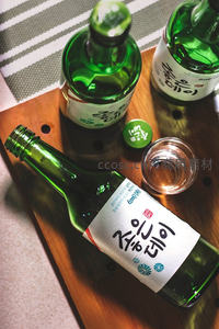 韩国清酒烧酒绿瓶斜置木盘，配小杯与瓶盖，日式简约风格餐桌静物
