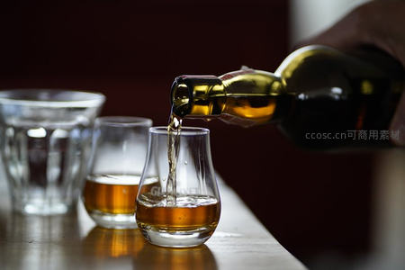 琥珀色烈酒倾入品鉴杯，液体飞溅瞬间凝固，彰显专业品酒仪式感