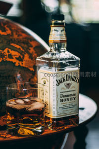 杰克丹尼蜂蜜威士忌配冰饮，复古地球仪背景增添文化气息