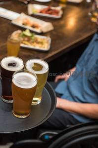 三杯风味啤酒置于托盘，搭配小食共享的惬意社交时光