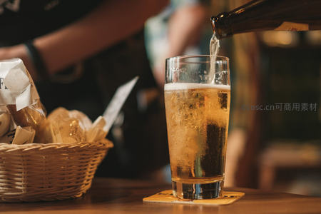 冰镇啤酒入杯瞬间，气泡升腾与藤编篮小食构成经典吧台画面