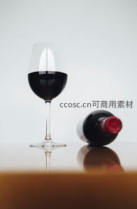 高脚杯红酒与横卧酒瓶极简静物构图