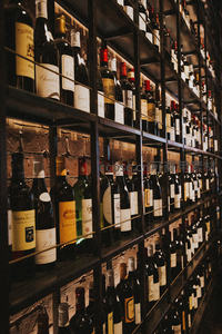 酒窖式酒架陈列多款葡萄酒，砖墙与金属架交织复古工业风