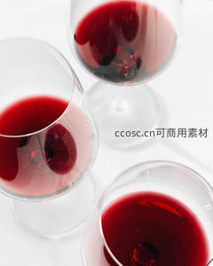 三只高脚杯盛红酒俯拍视角，晶莹酒液与光斑交织简约高级感