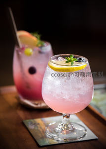 粉红气泡鸡尾酒特写，柠檬片与迷迭香点缀，冰珠凝结杯壁