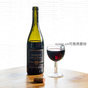 阿玛罗内红酒静置木桌，酒瓶标签清晰，软木塞旁配半杯醇红佳酿