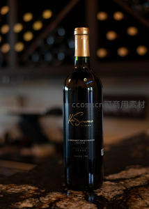 凯西蒙酒庄赤霞珠红酒瓶特写，深色酒标金箔点缀，置于花岗岩台面