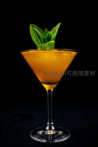 金橙色鸡尾酒配新鲜薄荷叶，黑色背景高光特写