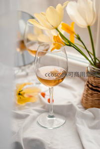 白葡萄酒杯与郁金香静物，柔光布艺背景下的春日雅致
