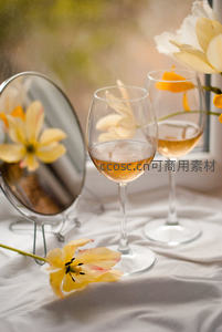 窗边柔光下两杯桃红葡萄酒与黄花镜面倒影，清新雅致生活场景
