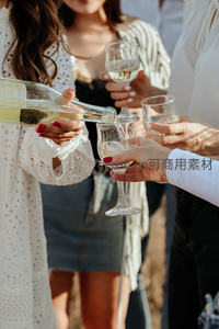 朋友举杯共饮：女士为同伴斟倒起泡酒的温馨瞬间