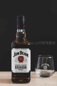 杰克丹尼威士忌瓶与空杯静物，黑底木质台面质感突出