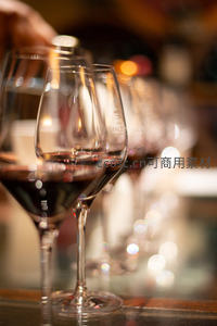 酒窖中排列的红酒杯，焦外光斑闪烁，营造朦胧醉人品鉴氛围