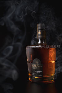 烟雾缭绕中的单一麦芽威士忌酒瓶，光影交错显奢华