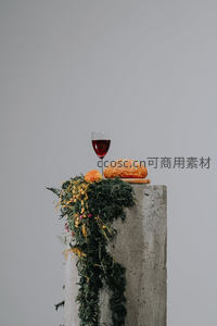 混凝土台上的红酒面包与花环静物艺术摆拍
