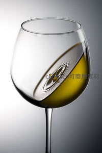 一滴酒液落入酒杯激起同心涟漪，光影折射下的微观艺术瞬间