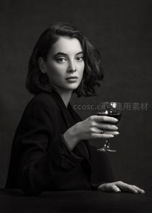 黑白肖像中女子手持红酒杯凝视镜头