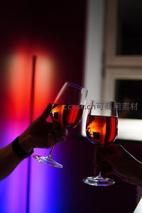 霓虹灯光下两人举杯碰杯庆祝瞬间