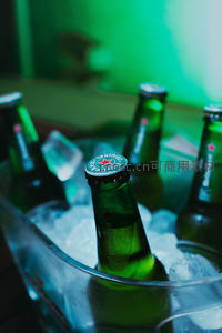 绿色喜力啤酒瓶置于冰桶中霓虹绿光映照