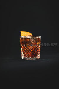 琥珀色古典鸡尾酒特写：雕花杯中橙皮点缀