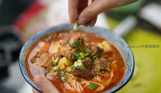手撒葱花瞬间：热腾腾红油牛肉面特写，香气扑鼻诱人