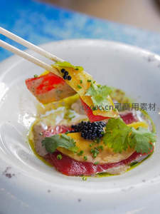 精致生鱼片配鱼子酱与香菜，筷子轻夹呈现鲜嫩质感