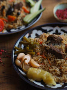 传统 Uzbek Plov 抓饭特写，牛肉胡萝卜米饭配腌蒜与青椒
