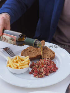 法式生牛肉塔塔配黑麦面包与薯条，橄榄油淋洒瞬间