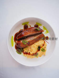 香煎鸭胸配南瓜泥与香草油，精致摆盘的法式料理特写