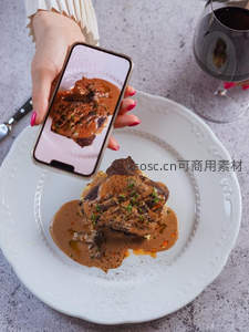 手机拍摄牛排特写，酱汁浓郁撒香草，白瓷盘优雅呈现美食瞬间