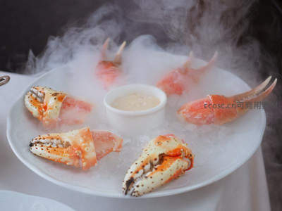 冰雾缭绕的帝王蟹钳特写，搭配柠檬与蘸酱，高端海鲜料理呈现