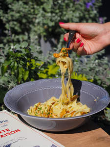 叉起香草蘑菇意面，红甲指尖与蓝碗形成鲜明对比