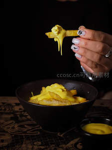 暗调背景下芝士拉丝薯条特写，手部美甲细节突出