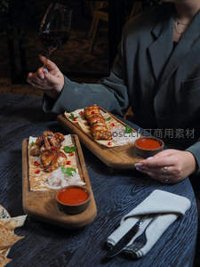 木质托盘上的烤鸡翅与烤肉串，佐以红酱与红酒优雅品鉴