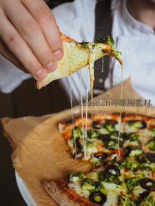 拉丝芝士披萨切片特写，绿色酱料与黑橄榄点缀的意式风味