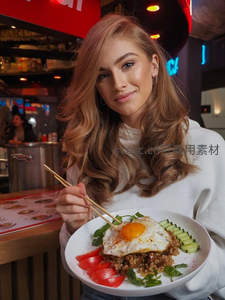 年轻女性手持泰式炒饭配煎蛋，霓虹灯下微笑展示美食瞬间