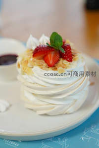 蛋白霜巴甫洛娃蛋糕，覆以草莓、杏仁片与薄荷叶